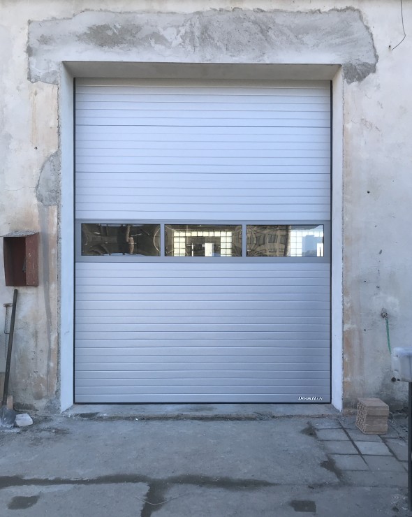sekční průmyslová vrata s prosvětlovacím panelem - stříbrná lamela, povrch stucco