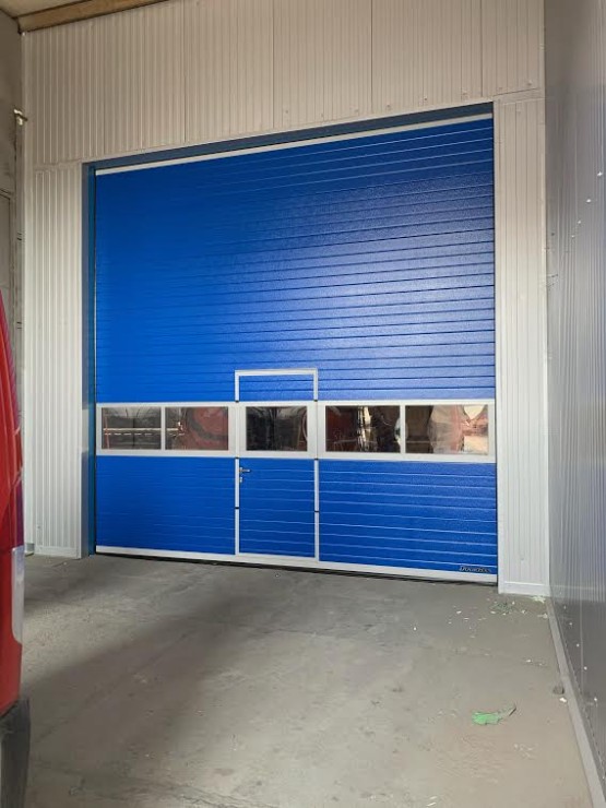 sekční průmyslová vrata - modrá RAL 5005, povrch lamela stucco, celoprosklenný ALU panel, vst. dveře